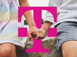 Zwei Kinder geben sich die Hand mit einem Telekom Logo